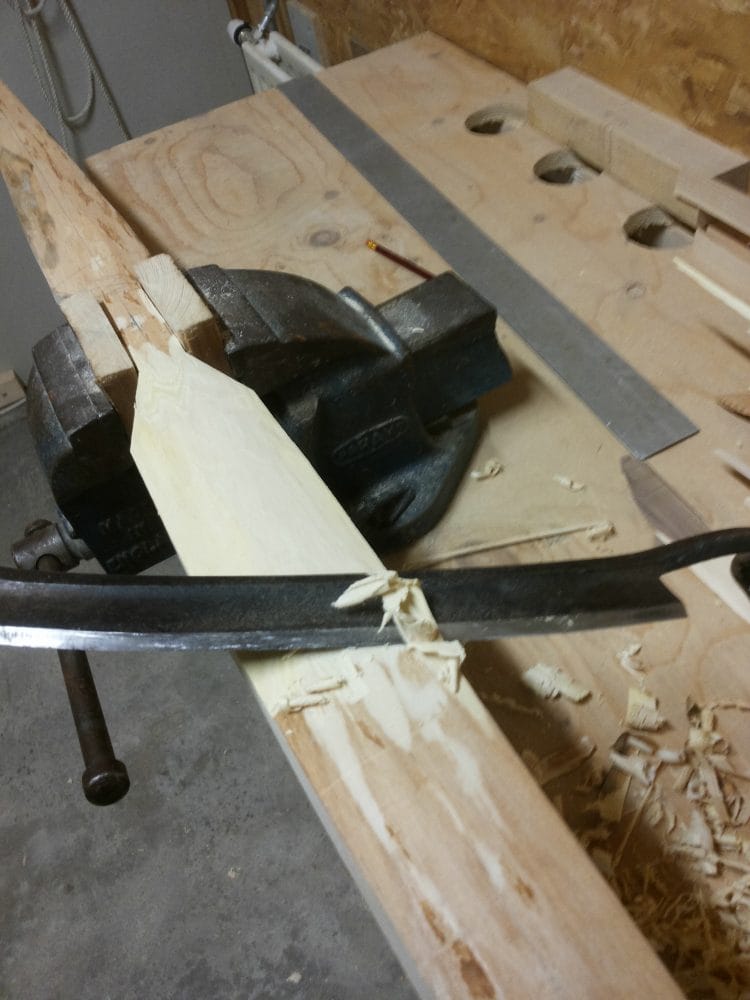 Boog van iep (iepen) hout in verschillende stadia van het maken. De boogstaaf wordt met gereedschap zoals een schaaf bewerkt tot een houten boog.