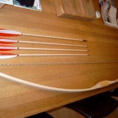 Een set houten zelf te maken boog en pijlen, met handvat, pees, veren en punten. Zo kan een complete houten boog gemaakt worden.