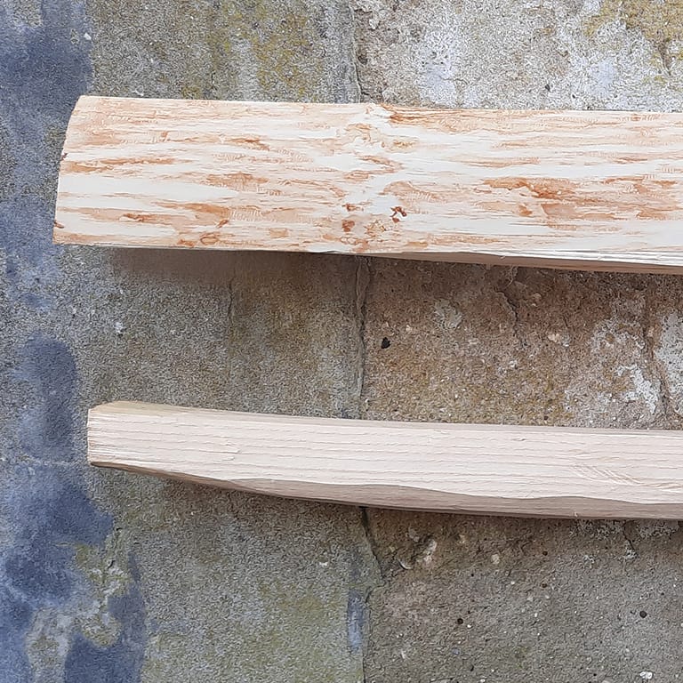 Close-up van de uiteinden (nokken) van een gekloofde boogstaaf van Essen voor een zelfgemaakte houten boog.